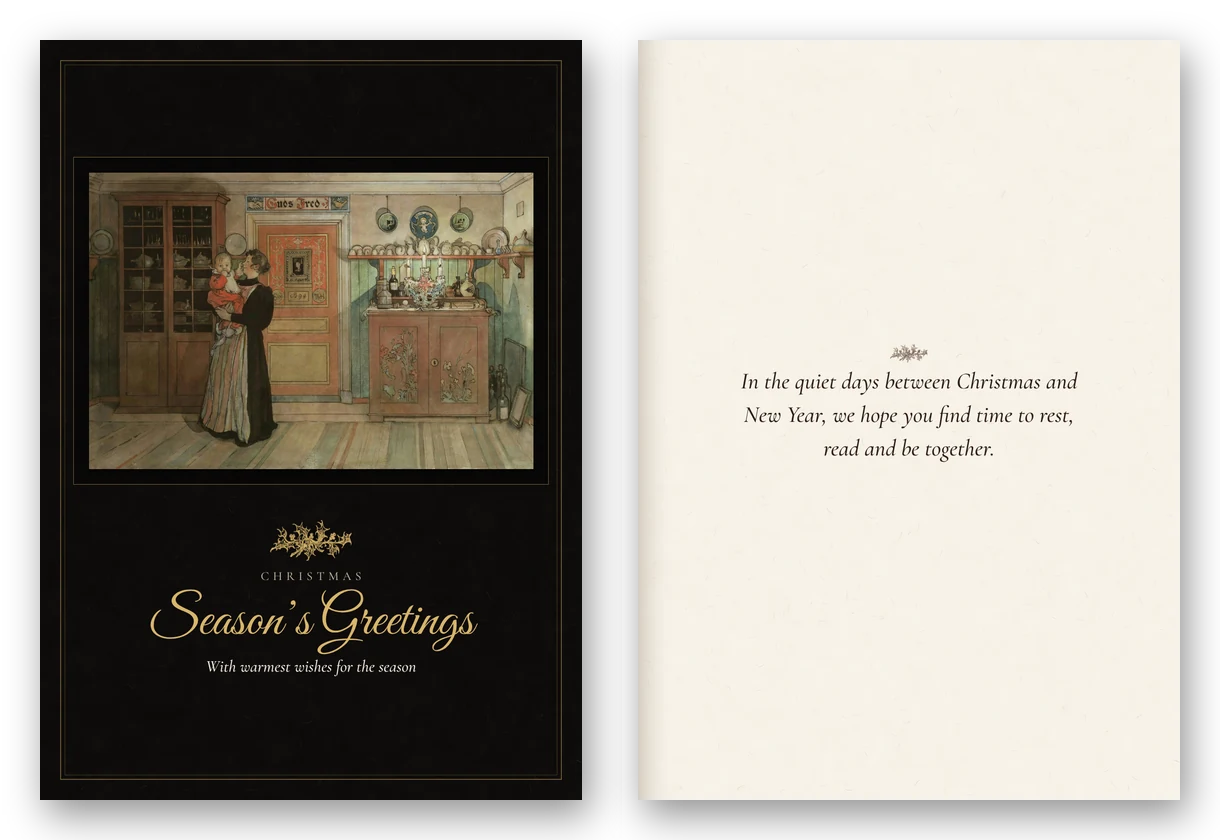 A tall dark card with Carl Larsson's painting of a mother holding a small child in a candlelit room, lettered Season's Greetings in gold script, beside the open card.